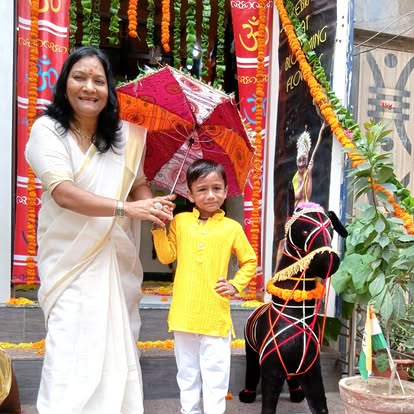 Meenakshi Ma'am with a student at the decorated school entrance