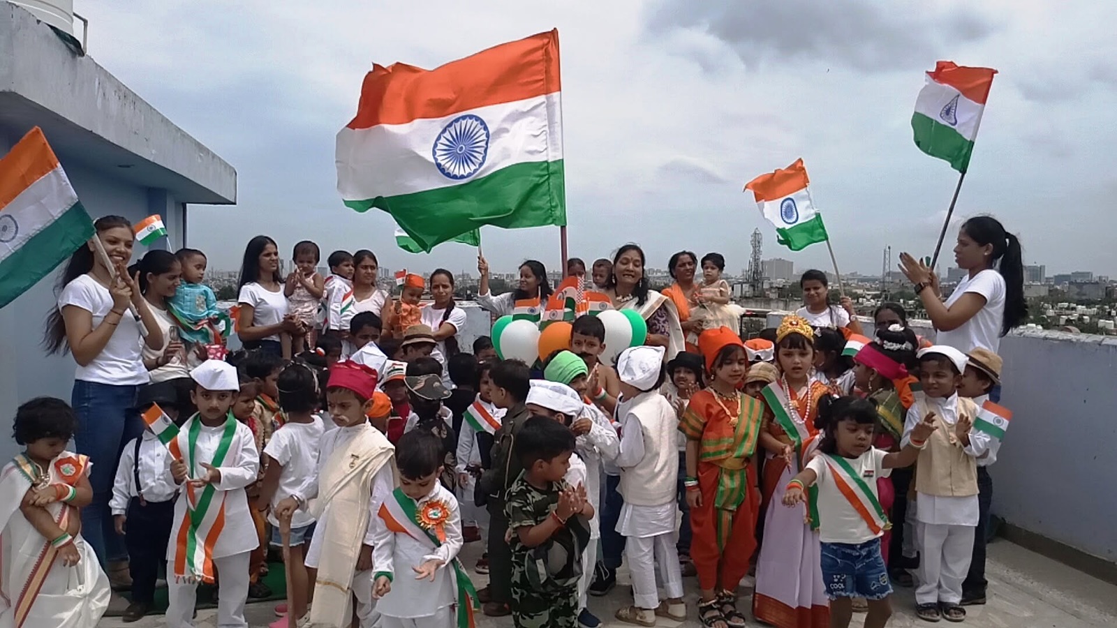 Children and teachers with Indian flags on the school rooftop