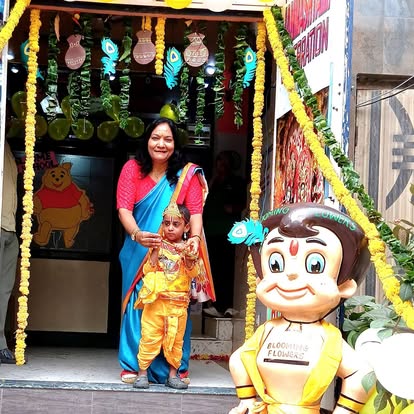 Meenakshi Ma'am with a child dressed as Krishna at the school entrance