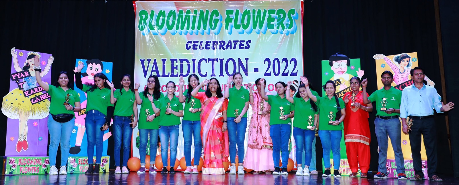 The Blooming Flowers teachers in green on stage at Valediction 2022